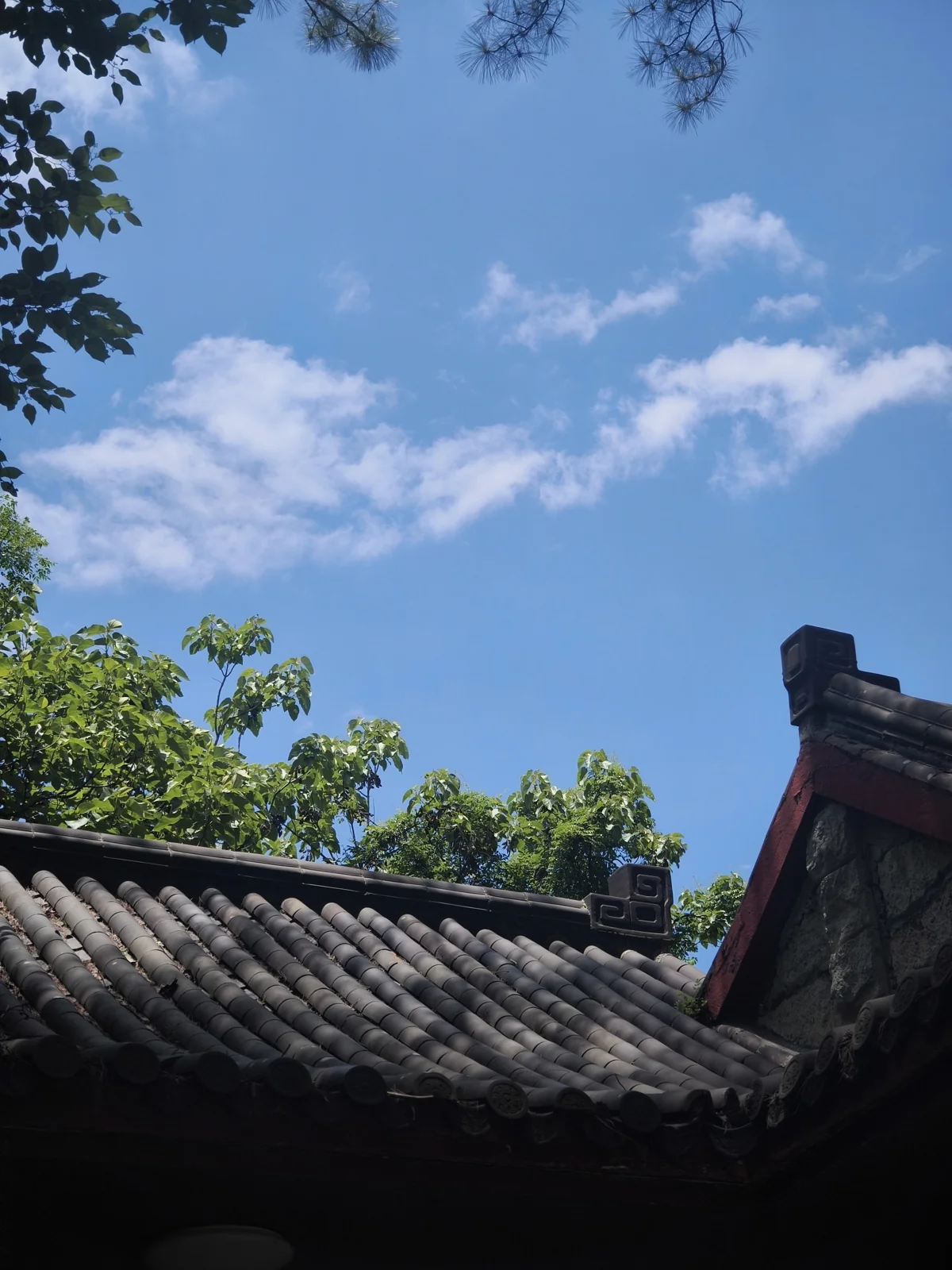青瓦屋檐一角与晴朗无云的蓝天