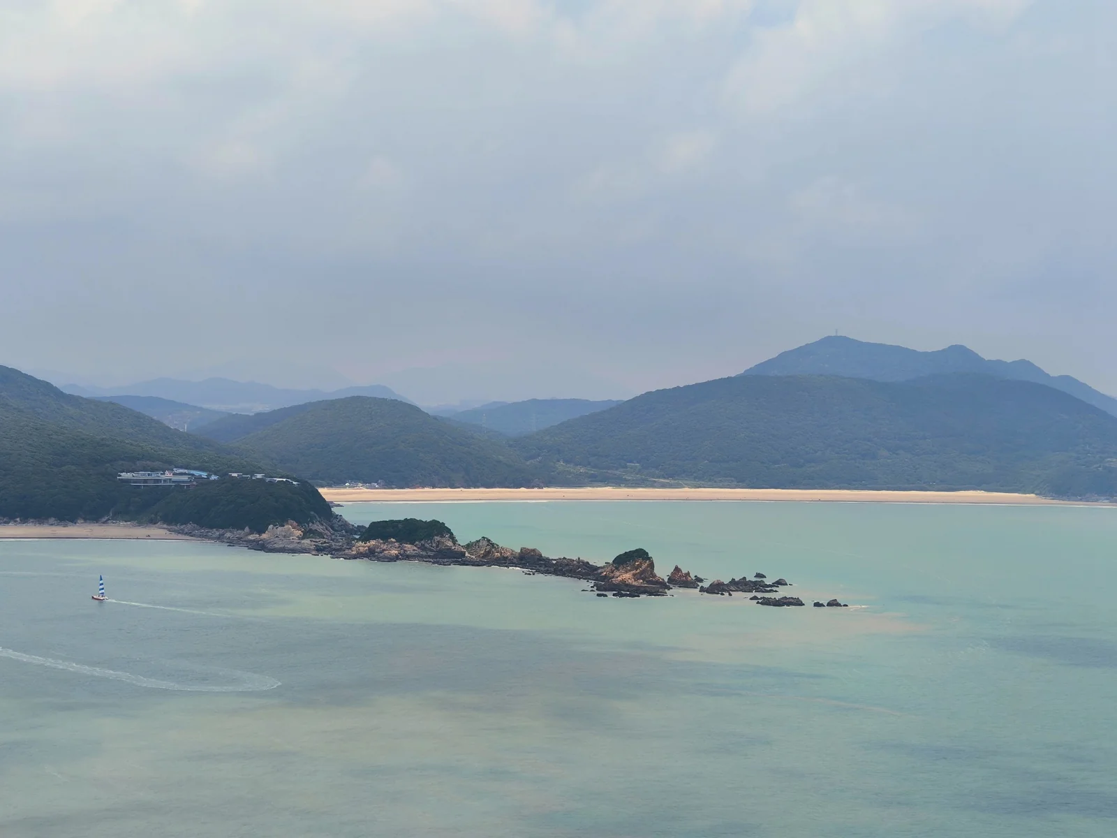 大青山俯瞰海湾，碧水环绕着礁石、沙滩与远山