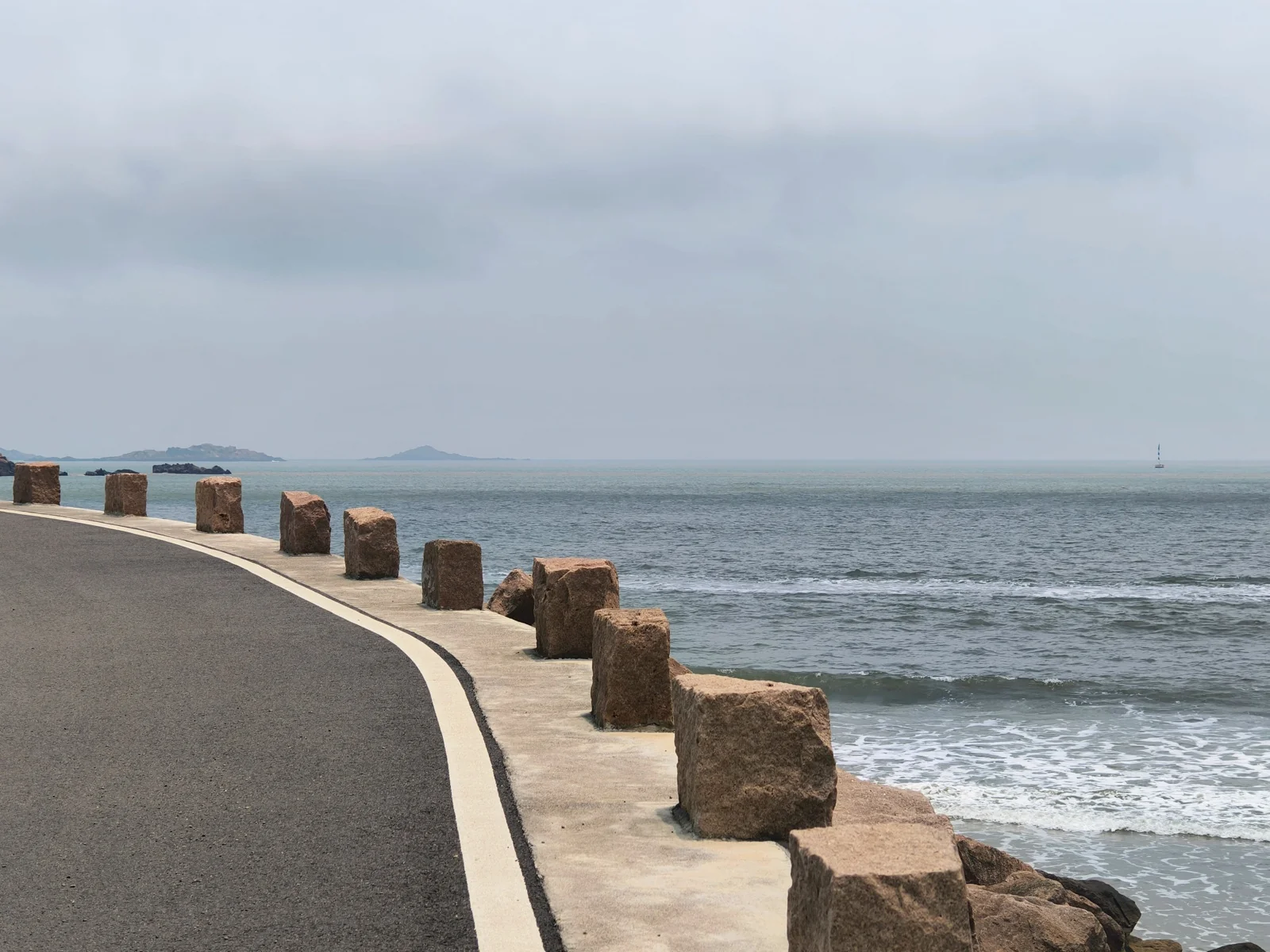 大青山沿海公路旁的海景，路边设有石墩护栏