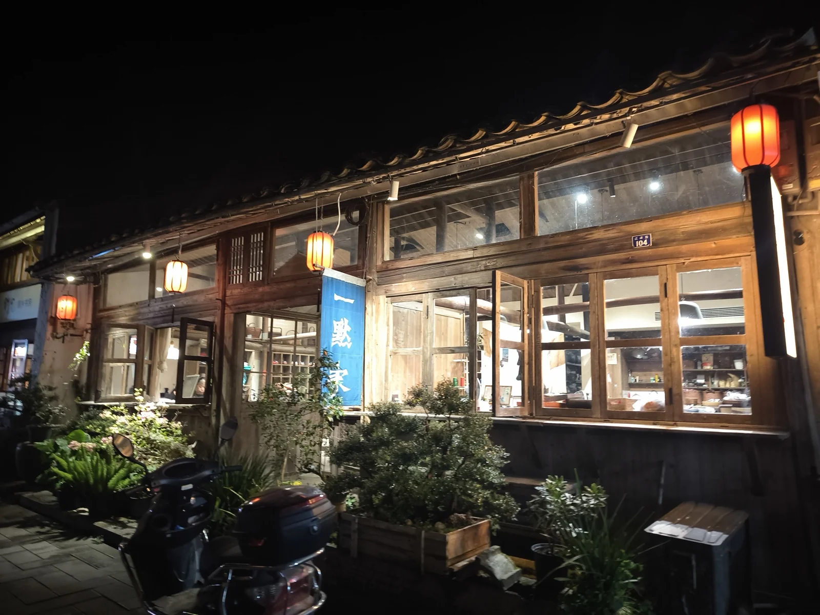夜色中的老街店铺，木格窗透出暖光，檐下挂着红灯笼